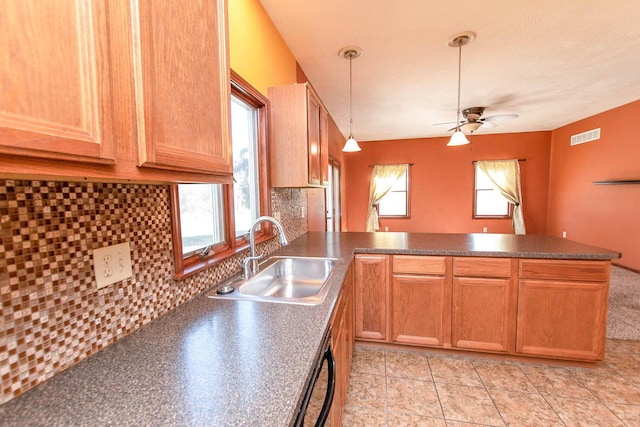 kitchen featuring a sink, a ceiling fan, a peninsula, visible vents, and dark countertops