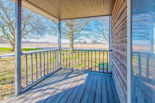 deck with a rural view and a yard