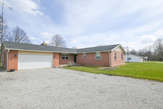 ranch-style home featuring a front yard, a chimney, an attached garage, brick siding, and gravel driveway