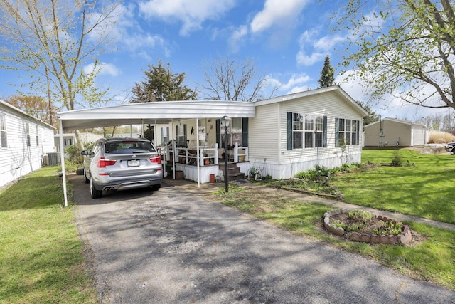 view of front of property featuring a front lawn, cooling unit, an attached carport, and driveway