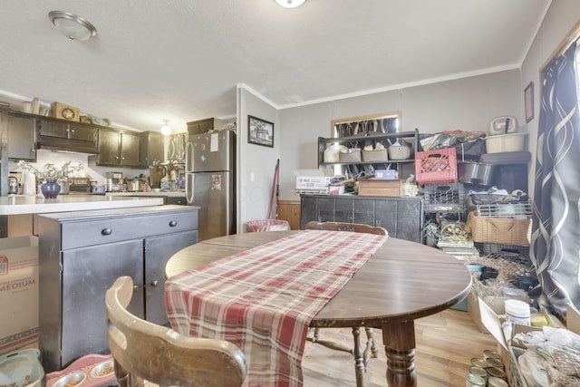 dining space with crown molding and light wood-style flooring