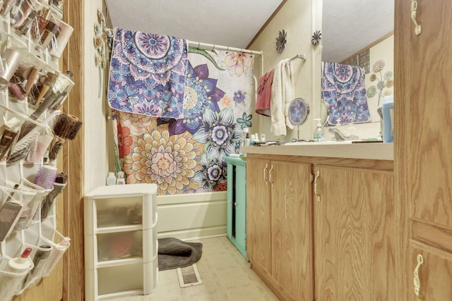 bathroom with a textured ceiling, vanity, shower / tub combo with curtain, and tile patterned floors