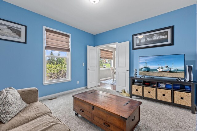 carpeted living area featuring visible vents and baseboards