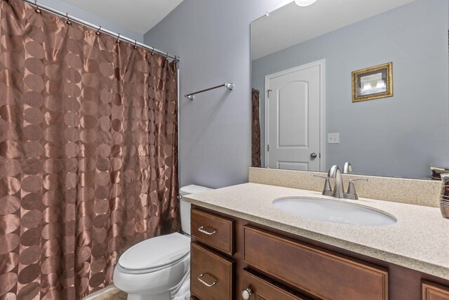 full bath with toilet, vanity, and curtained shower
