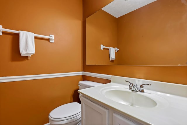 half bathroom featuring toilet and vanity