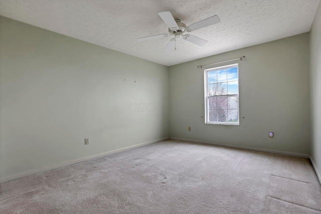 carpeted empty room with a textured ceiling, baseboards, and ceiling fan