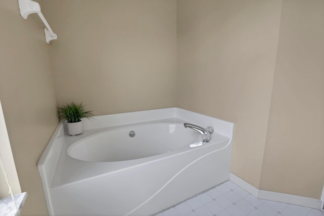 full bath with a bath and baseboards