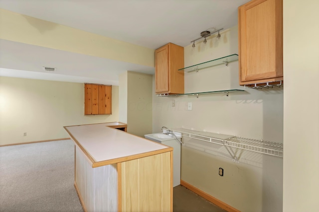 kitchen featuring light brown cabinets, baseboards, light carpet, light countertops, and visible vents