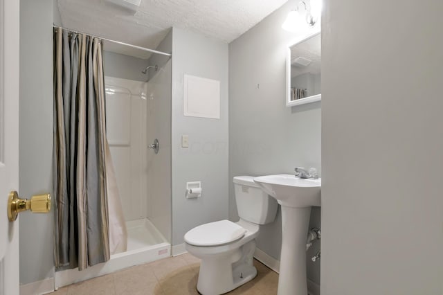 full bathroom with baseboards, a stall shower, tile patterned flooring, toilet, and a sink