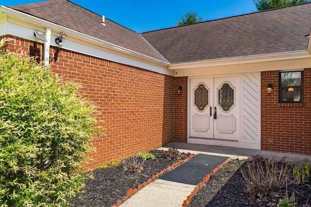 property entrance with brick siding and roof with shingles