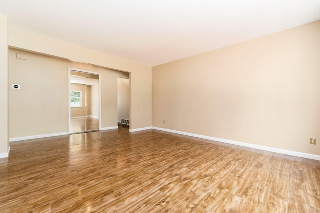 unfurnished room with baseboards and wood finished floors