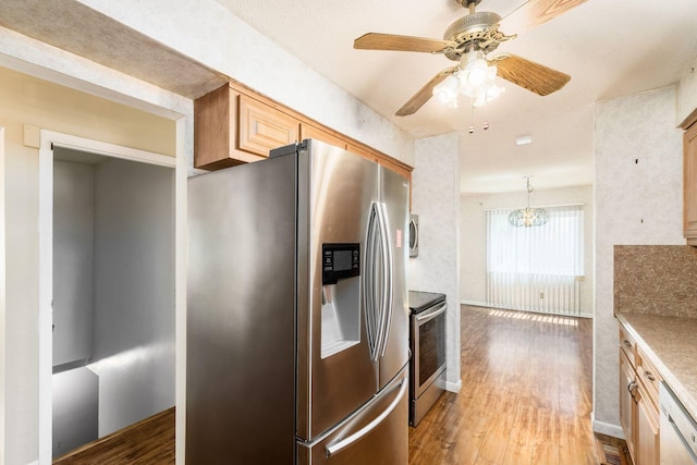 kitchen featuring wood finished floors, ceiling fan with notable chandelier, light brown cabinets, baseboards, and appliances with stainless steel finishes