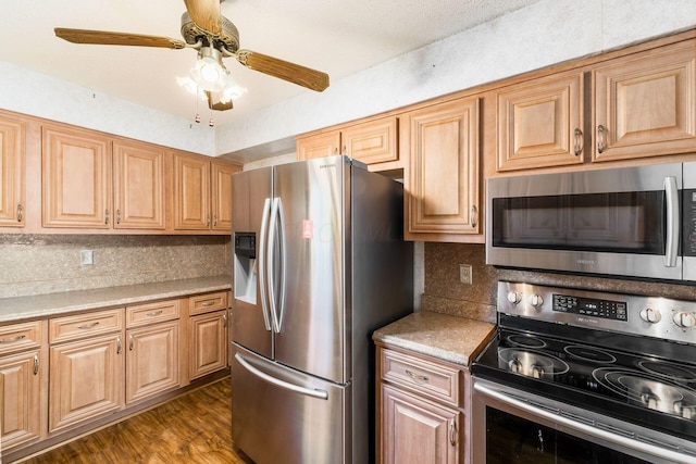 kitchen with ceiling fan, light countertops, stainless steel appliances, decorative backsplash, and wood finished floors