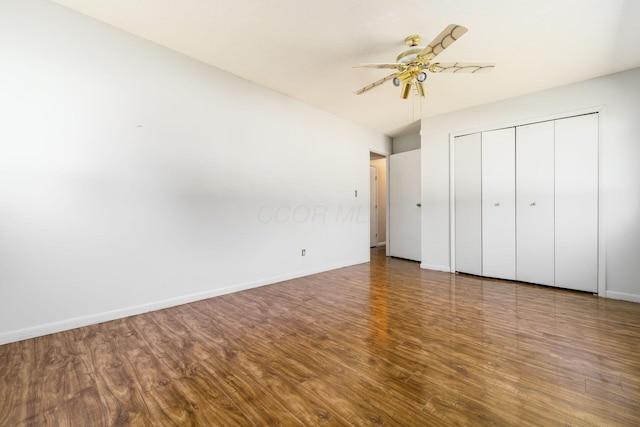 unfurnished bedroom with baseboards, a ceiling fan, a closet, and wood finished floors