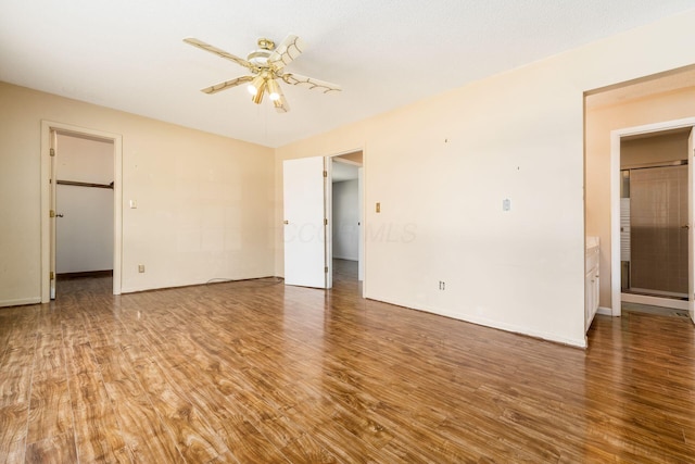 empty room with baseboards, ceiling fan, and wood finished floors