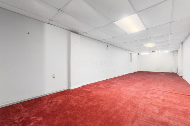 basement with baseboards, carpet, and a drop ceiling