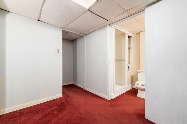 finished basement with baseboards, carpet, and a paneled ceiling