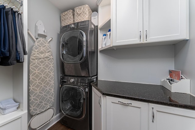 washroom featuring cabinet space and stacked washing maching and dryer
