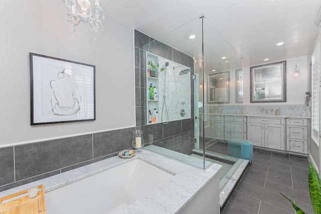 bathroom with tile patterned flooring, vanity, recessed lighting, an inviting chandelier, and a stall shower