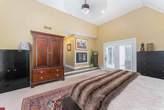 bedroom with light colored carpet, high vaulted ceiling, baseboards, access to exterior, and visible vents