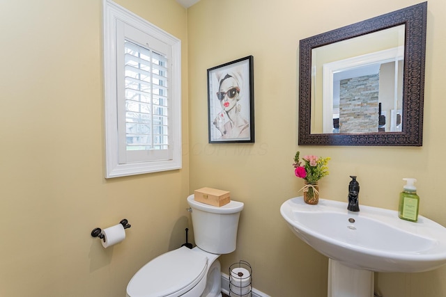 bathroom with baseboards, a sink, and toilet