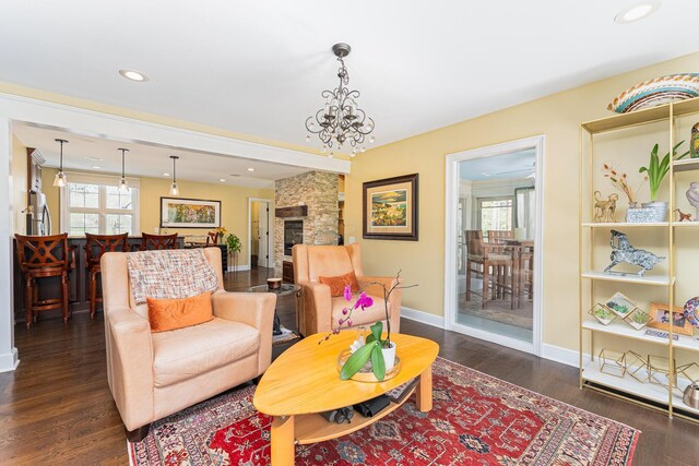 living area featuring recessed lighting, an inviting chandelier, baseboards, dark wood-style floors, and a fireplace