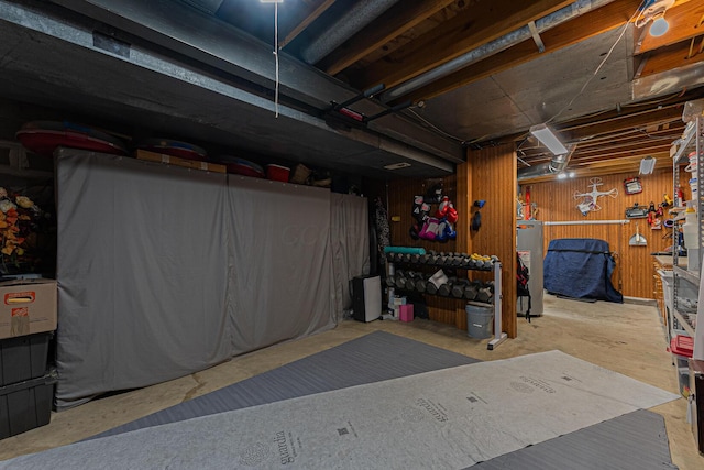 unfinished basement with gas water heater and wooden walls
