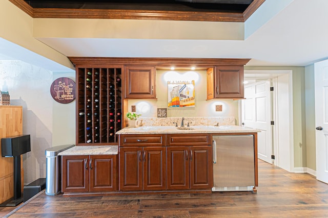 bar featuring fridge, baseboards, a sink, and dark wood-type flooring