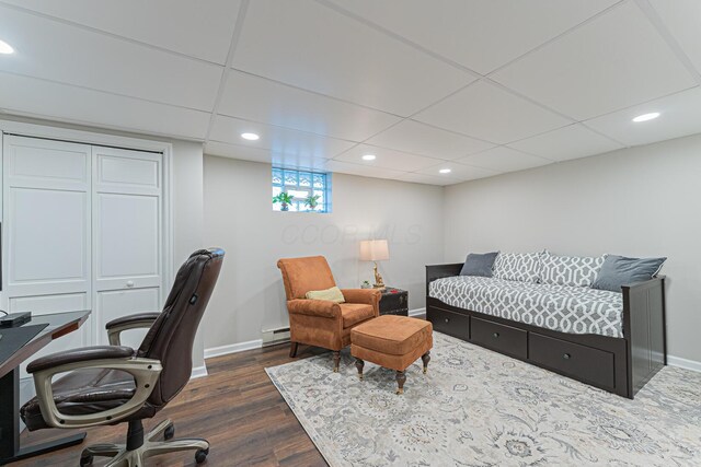 bedroom featuring a baseboard heating unit, recessed lighting, dark wood-style flooring, baseboards, and a paneled ceiling