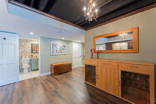bar with dark wood-style floors, visible vents, baseboards, and an inviting chandelier