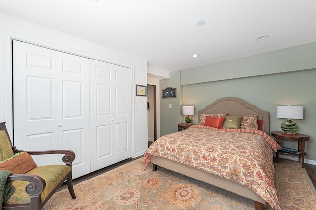 bedroom featuring a closet, baseboards, wood finished floors, and recessed lighting