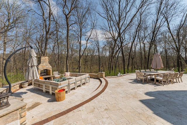 view of patio with outdoor dining space and an outdoor stone fireplace