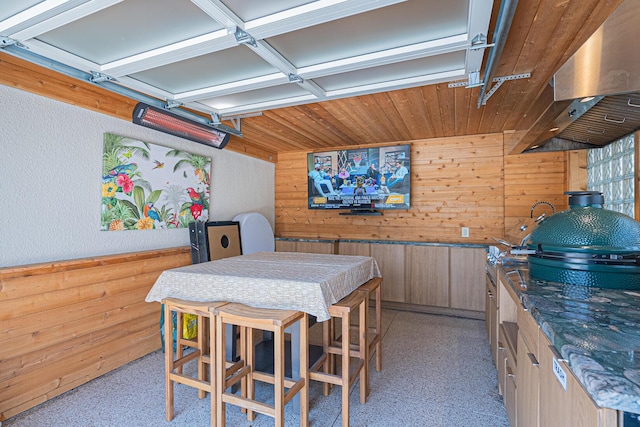 dining area with wooden ceiling and wooden walls
