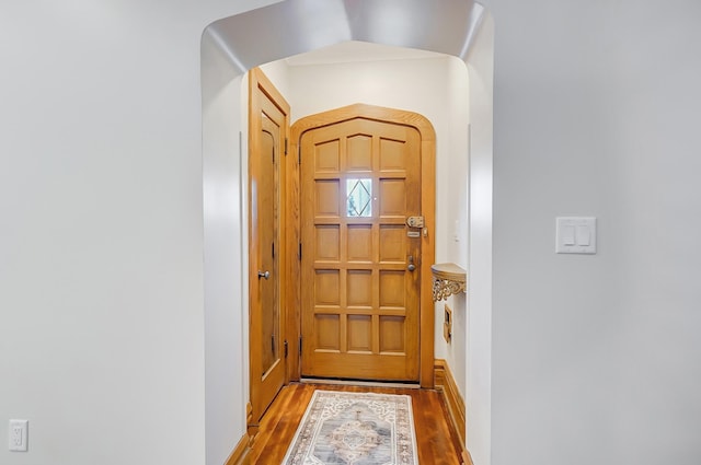 entryway featuring arched walkways and wood finished floors