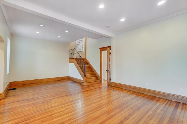 spare room with baseboards, light wood-style flooring, visible vents, and stairway