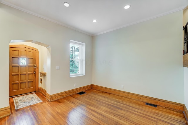 foyer with ornamental molding, visible vents, and light wood-type flooring