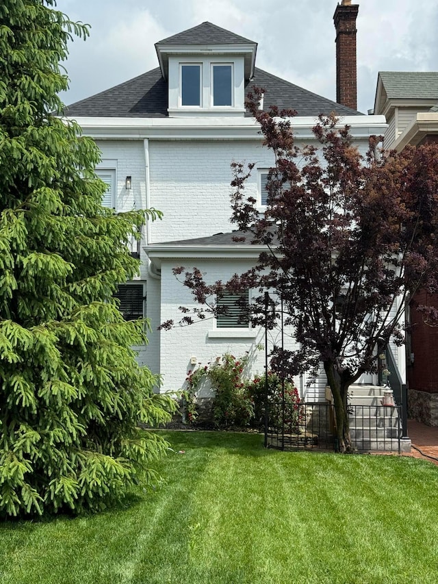1021 E Livingston Ave, Columbus, OH 43205 - view of side of property with brick siding, a lawn, a chimney, and a shingled roof