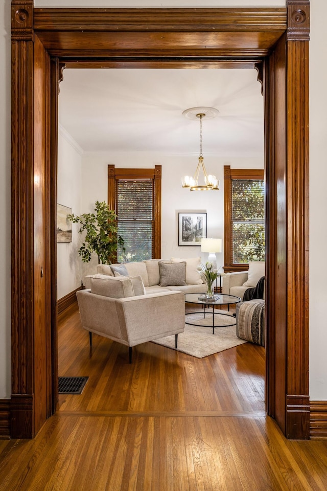 160 E Moler St, Columbus, OH 43207 - living area featuring wood-type flooring, a chandelier, ornamental molding, and baseboards