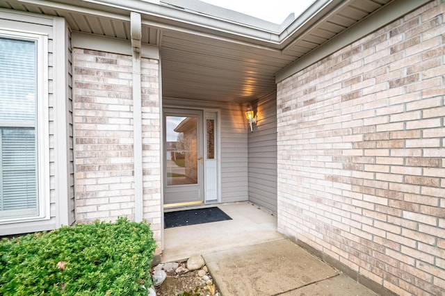 view of exterior entry with brick siding