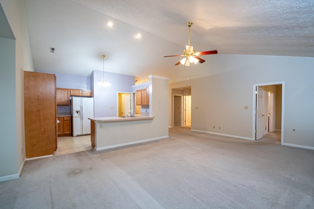 unfurnished living room featuring high vaulted ceiling, ceiling fan with notable chandelier, a textured ceiling, baseboards, and light colored carpet