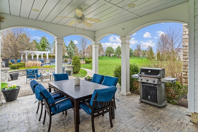 view of patio featuring outdoor dining area, ceiling fan, area for grilling, and a pergola
