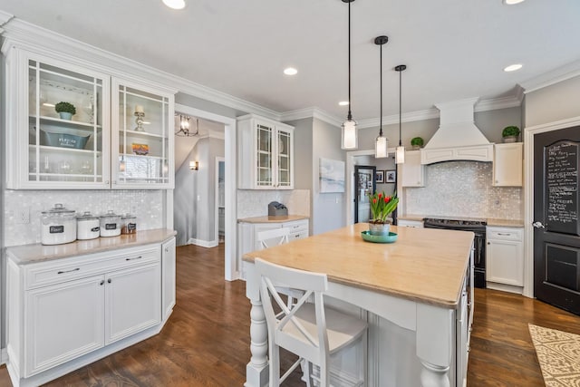 kitchen with a kitchen island, light countertops, black / electric stove, and premium range hood
