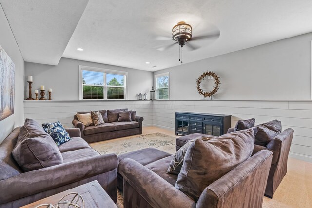 living area with recessed lighting, wooden walls, and ceiling fan