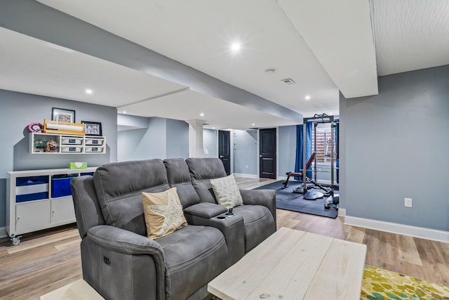 living area with baseboards, light wood-style floors, and visible vents