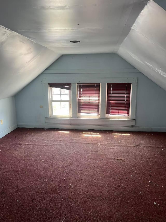 bonus room with baseboards, vaulted ceiling, and carpet flooring