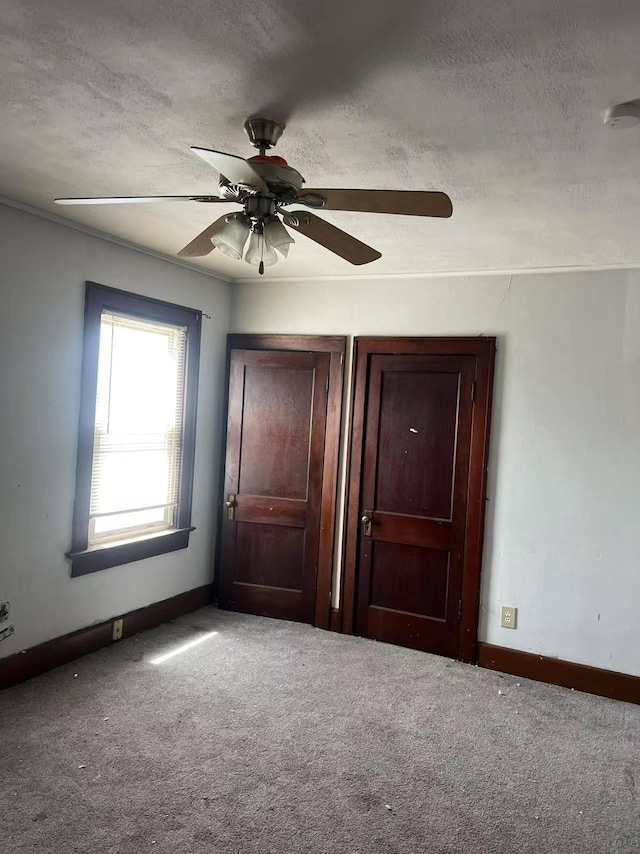 unfurnished bedroom featuring carpet floors, baseboards, and a textured ceiling