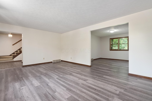 2520 Saltergate Dr, Dublin, OH 43016 - empty room with wood finished floors, stairway, and a textured ceiling