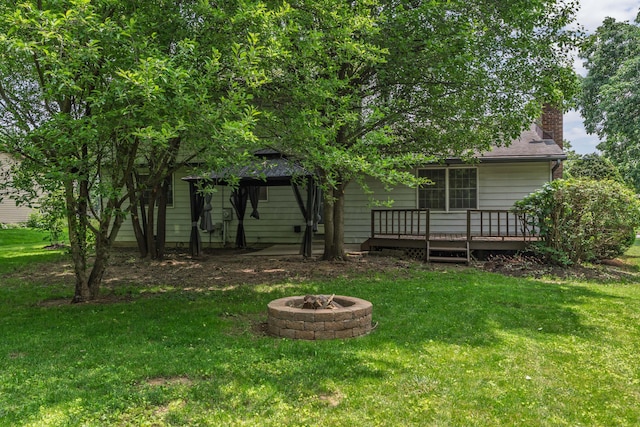 2520 Saltergate Dr, Dublin, OH 43016 - back of house featuring a wooden deck, an outdoor fire pit, a lawn, and a chimney