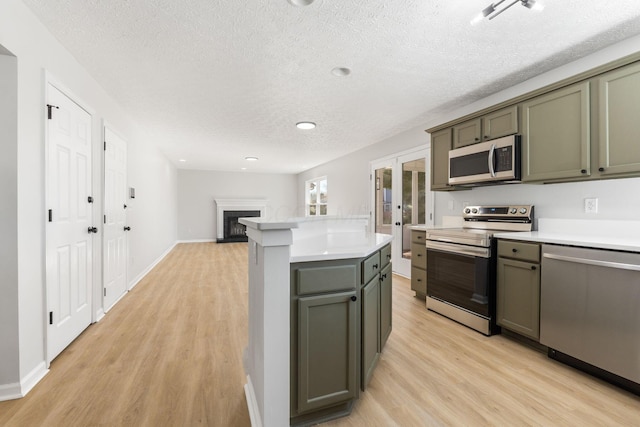632 Tall Oaks Dr, Gahanna, OH 43230 - kitchen with light countertops, a textured ceiling, appliances with stainless steel finishes, and light wood-style floors