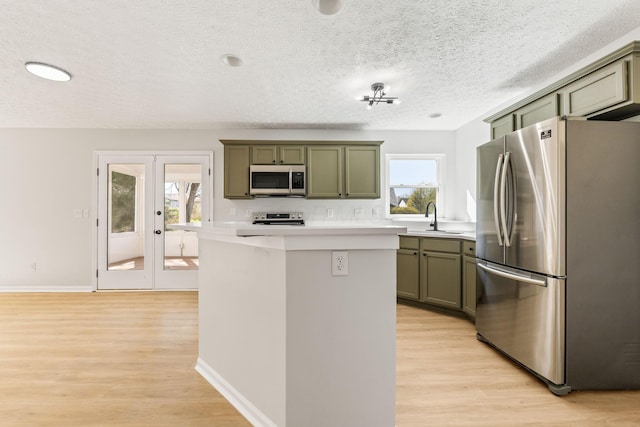 632 Tall Oaks Dr, Gahanna, OH 43230 - kitchen with green cabinetry, a sink, light wood finished floors, light countertops, and stainless steel appliances